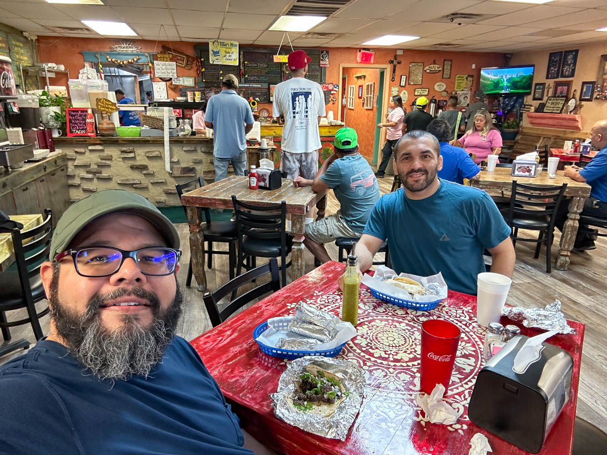 two men eating tacos