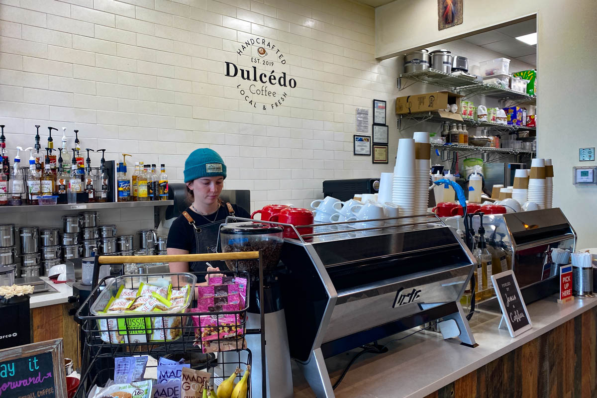 An employee making coffee at Dulcédo Coffee